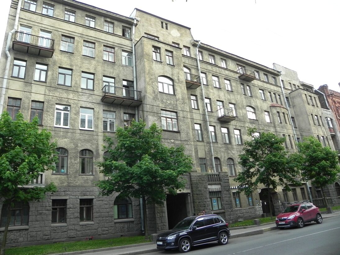 Фасад дома с арочным проездом в центре: гранитный руст нижнего яруса, светлая штукатурка выше